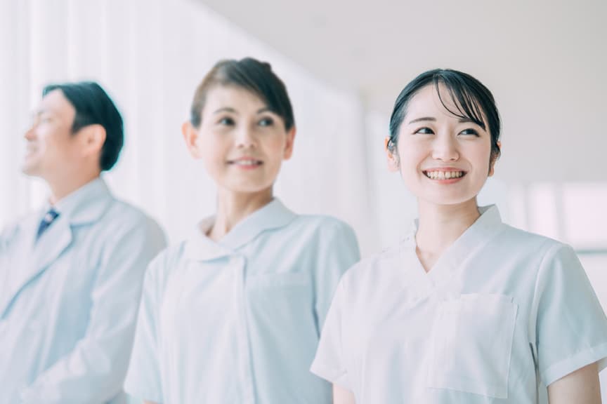 看護師たちが笑顔で前を見つめる様子