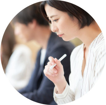 社会人女性が考えながらタブレットを操作しています。