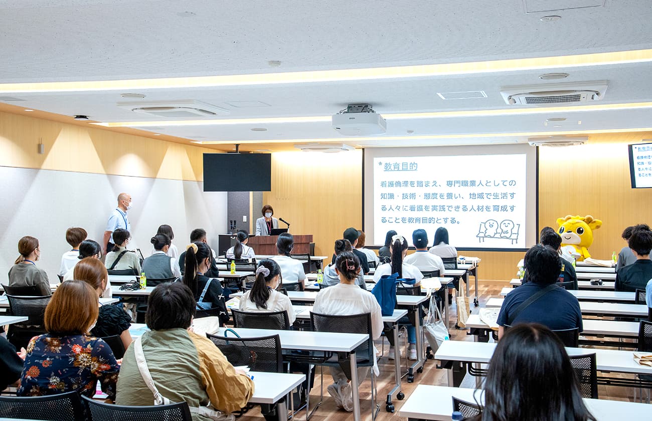 講義室で学校の教育目的について説明を受ける参加者たちの様子