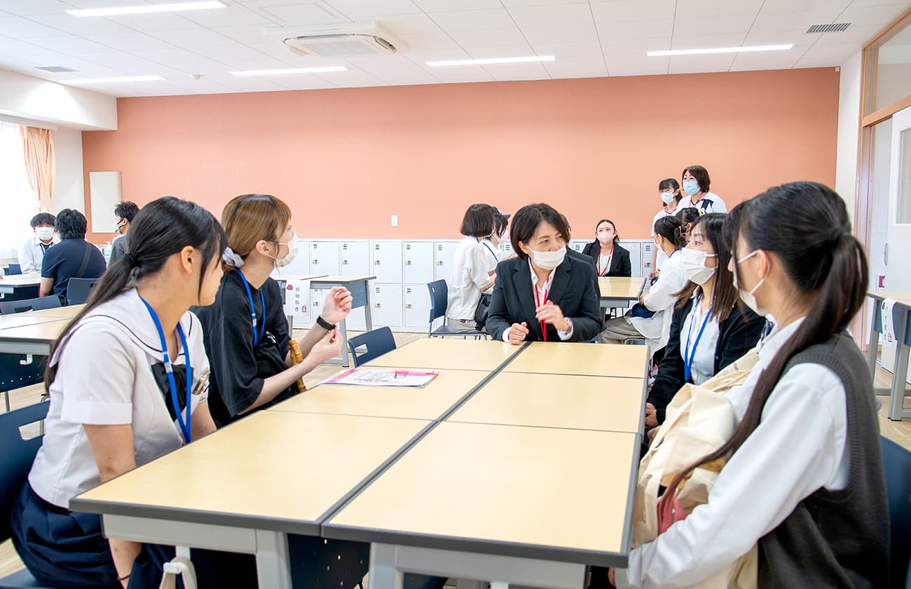 教室で学生と教員がグループに分かれて相談している様子